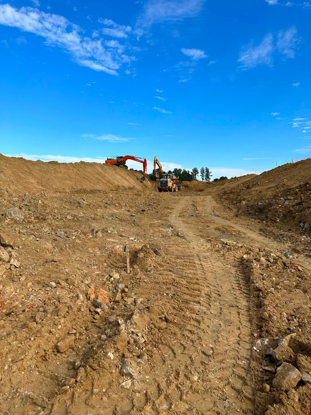 Precision Earth & Pipe heavy equipment cutting a roadway grade on site